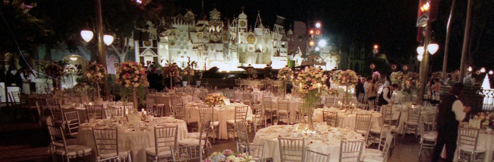 A large wedding reception outside of 'it's a small world'