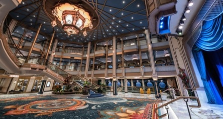 The Grand Hall glows with warm lighting on the Disney Treasure