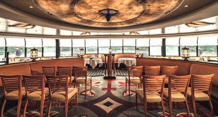Rows of chairs set up to face windows that reveal a view of the ocean