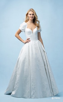 A bride wearing a Cinderella inspired ball gown featuring a sweetheart neckline with capped sleeves