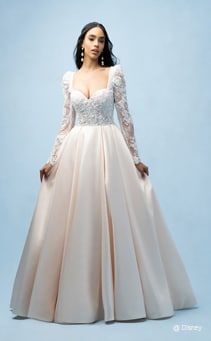 A bride wearing a Belle inspired ball gown featuring a sleeved, beaded bodice with a sweetheart neckline