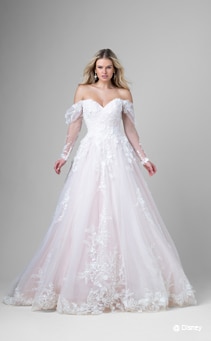 A bride wearing an Aurora inspired A line gown featuring an off the shoulder neckline and lace detail