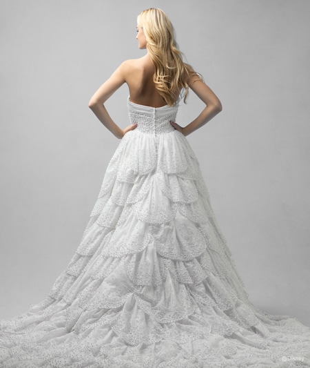 The back of a bride wearing an Ariel inspired ball gown featuring a beaded bodice and a ruffled train
