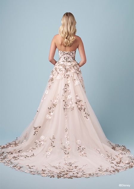 A bride wearing a Pocahontas inspired A line wedding gown featuring embroidery of leaves and blossoms