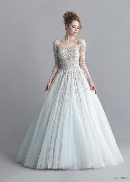 A woman stares down at the Cinderella wedding gown from the 2020 Disney Fairy Tale Weddings Platinum Collection that she is wearing