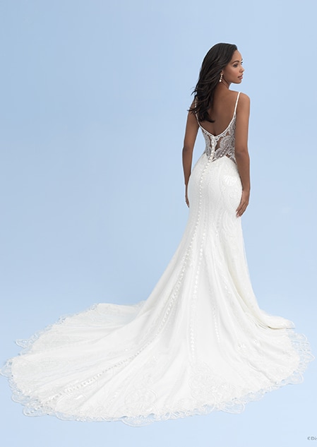 The back of a woman wearing a wedding dress with skinny straps and a lace see thru bodice and a skirt with a long train