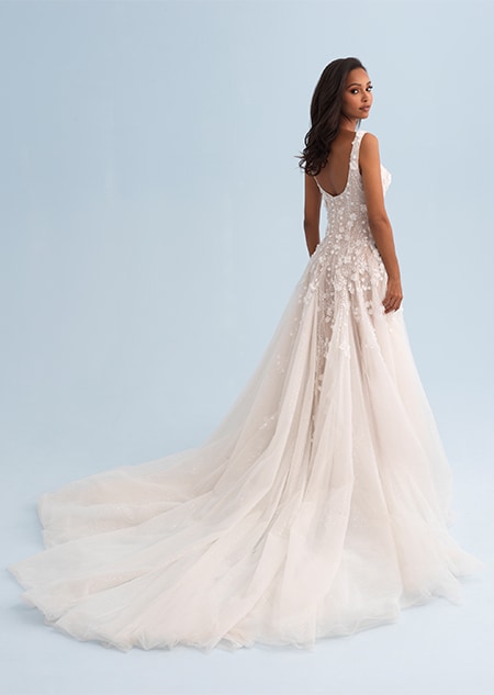 A woman looking over her shoulder wearing a long form fitting wedding dress covered in beads A woman looking over her shoulder wearing a long form fitting wedding dress covered in beads
