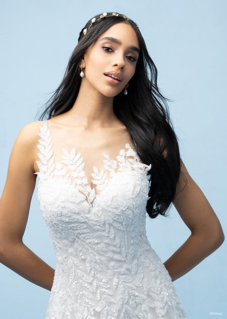 The bodice of a bride wearing a Pocahontas inspired A line gown featuring a sweetheart neckline and a bodice and straps with a beaded leaf design