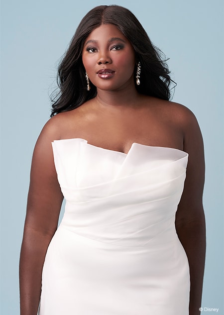 A bride wearing a strapless Tiana inspired gown featuring sheer fabric over a sweetheart neckline