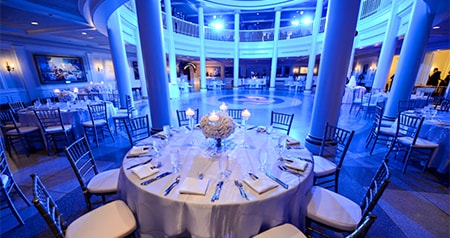 A spacious rotunda featuring large pillars and tables surrounding the center of the room