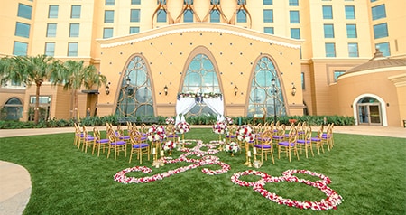 Chairs arranged on a lawn facing Gran Destino Tower with many windows and floral decorations