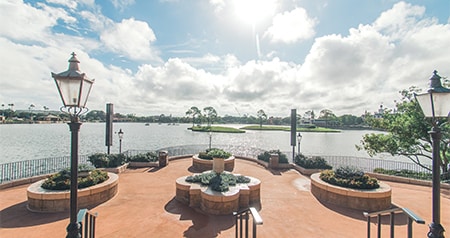 An outdoor waterfront venue with circular planters, vintage lampposts and a view of the lake 