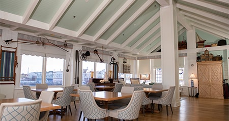 A wedding reception venue with tables and chairs facing windows overlooking Disney’s BoardWalk