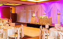 Several round tables, a small dance floor and a cake table
