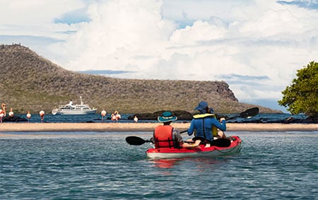 Newlyweds wearing life jackets while paddling the waters surrounding the Galápagos Islands