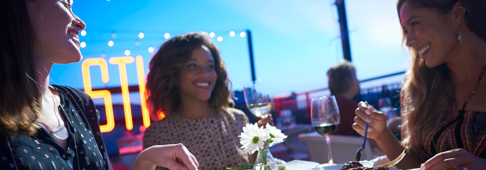 3 women smile, eat and drink at a restaurant table 3 women smile, eat and drink at a restaurant table