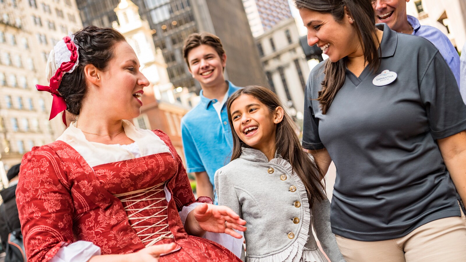 A woman in Colonial costume talking to a group of people in downtown Boston