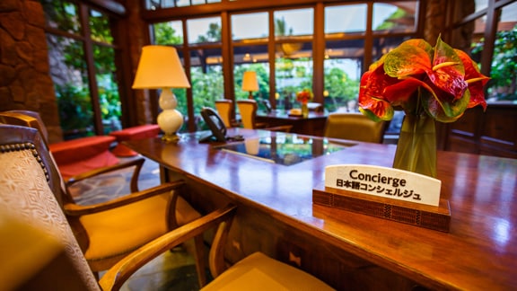 A desk with chairs in the lobby, with a sign that reads