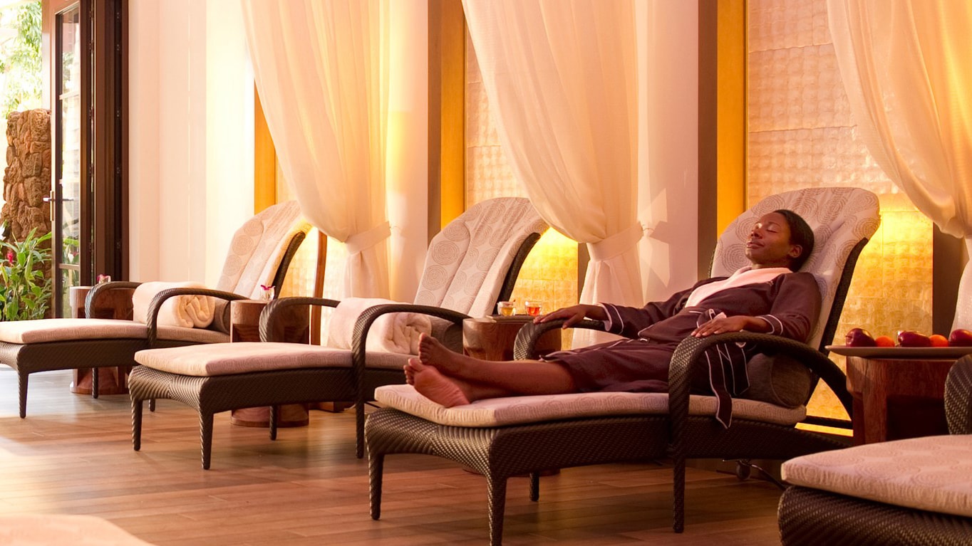 A woman in a luxurious robe relaxes as she stretches out in a cushioned lounge chair