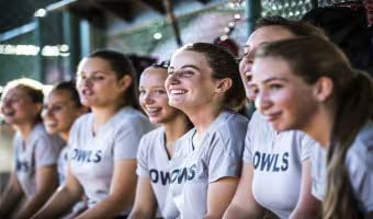 A women’s softball team sitting in the dugout of ESPN Wide World of Sports Complex