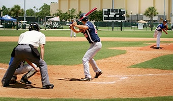 Credentials An umpire watches as a batter prepares to hit a baseball thrown by a pitcher