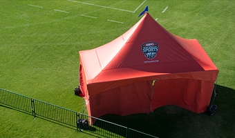 A large tent near the corner of a soccer field