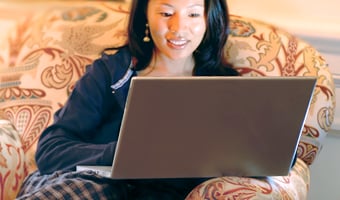 Additional Amenities A woman sits on a comfortable sofa and surfs the net on her laptop