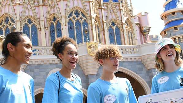 Disney Imagination Campus students examine hand drawn maps outside of Cinderella Castle